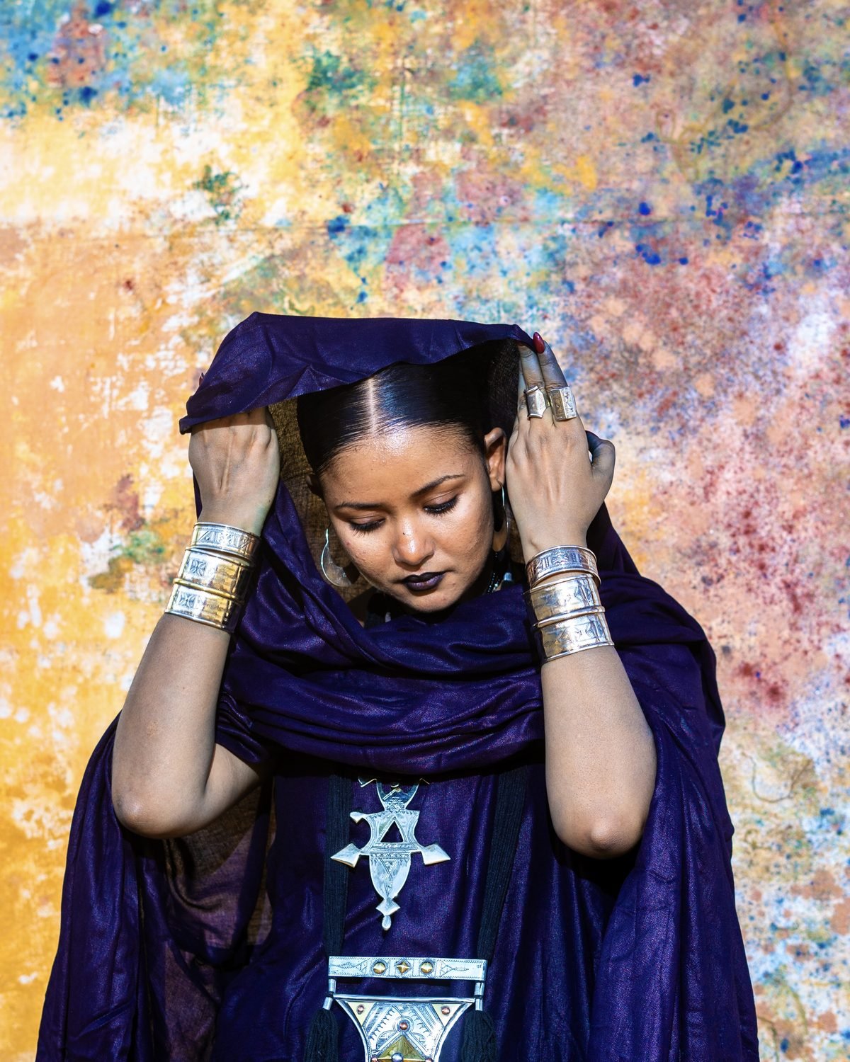 Portrait de Leila Walet Mohamed en tenue indigo avec bijoux Touareg